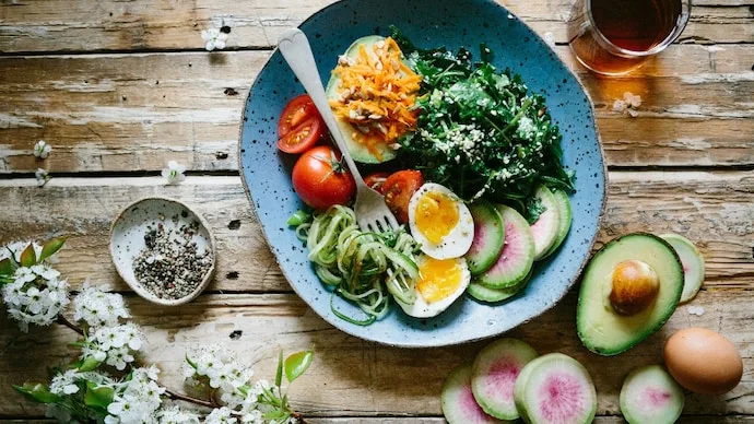 A balanced meal illustrating food sequencing, with vegetables and protein eaten before carbohydrate-rich foods to support fullness and blood sugar management.