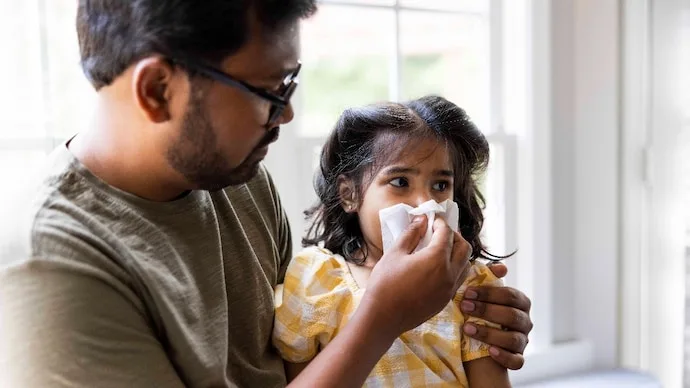 Parent caring for a young child experiencing nasal irritation during changing Delhi-NCR weather